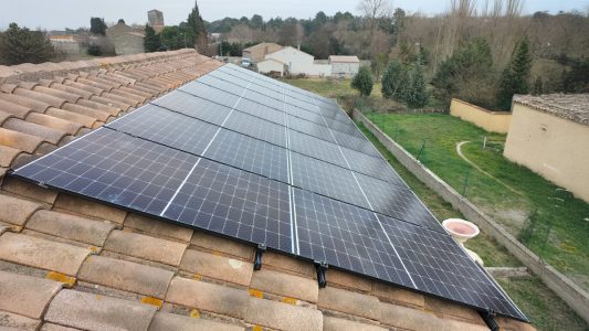 Panneaux solaires installés sur un toit de tuiles.