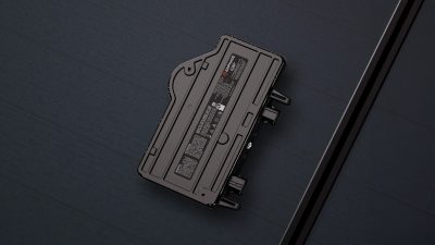 Un onduleur micro ENPHASE IQ8P sur un fond sombre avec des lignes diagonales.