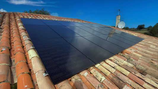 Panneaux solaires sur un toit de tuiles, ciel bleu, énergie renouvelable